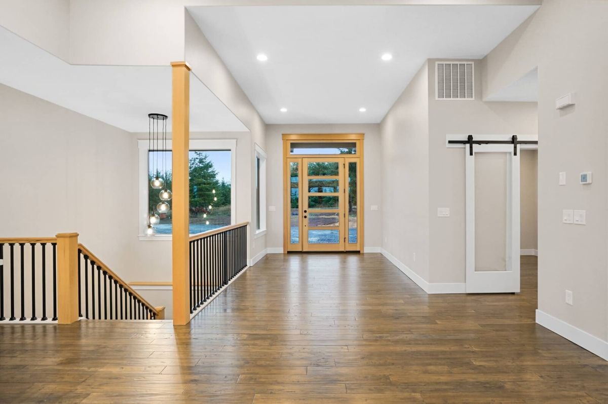 Foyer with wooden floors and custom lights.