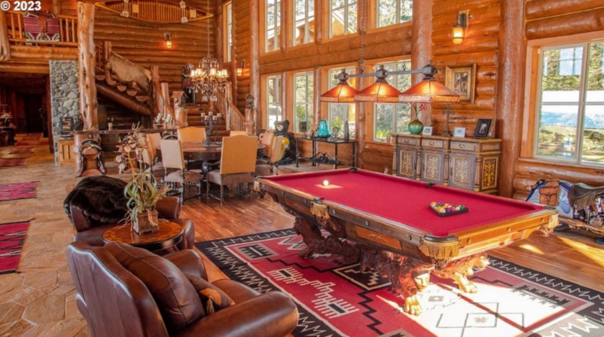 Billiards room with couches, a large rug and custom lights.