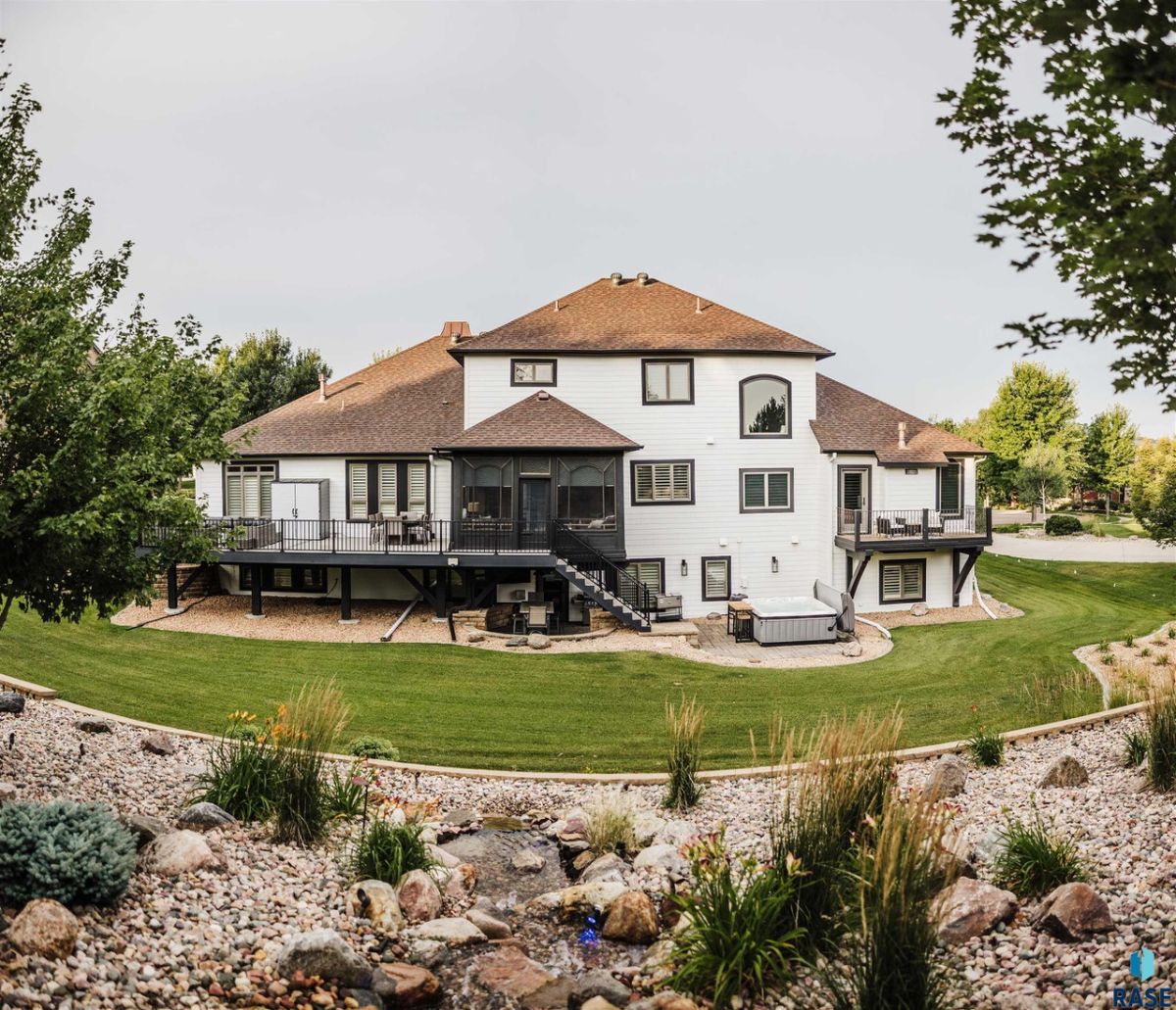 Rear view of the house with a large green lawn.
