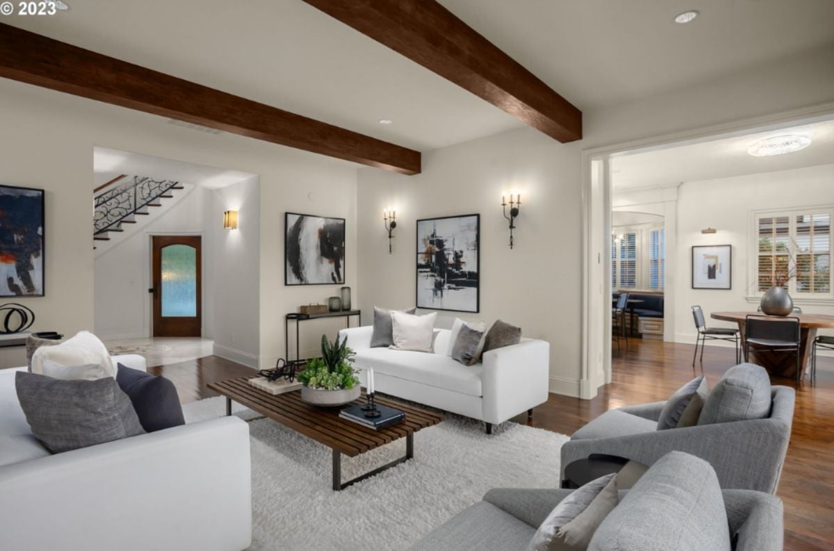 Living room with couches, custom lights, vaulted ceiling and a large rug.