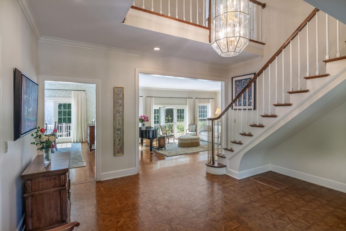 Foyer with a staircase and a chandelier.