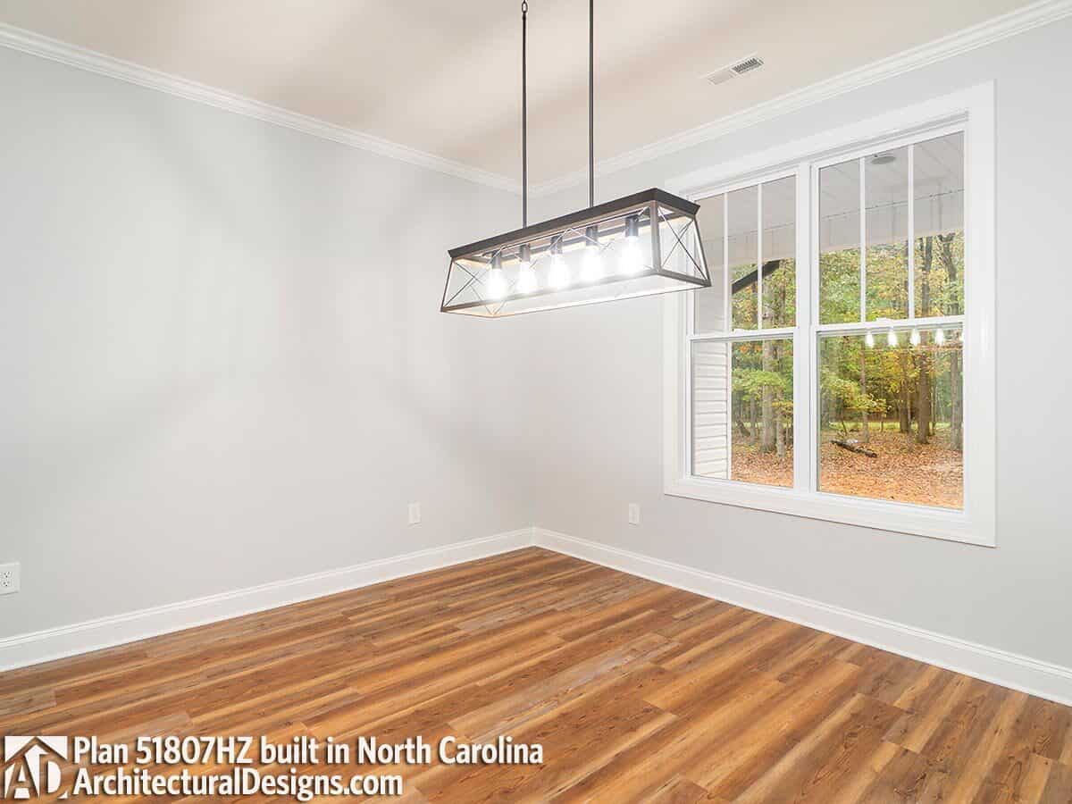 Dining room with linear chandelier and a view of the front porch.
