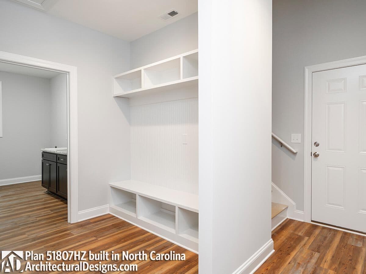 Mudroom with built-in cubbies and a connecting laundry room.