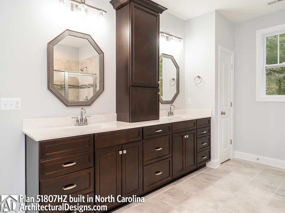 Primary vanity with two sinks, dark wood cabinets, and a couple of octagonal mirrors.