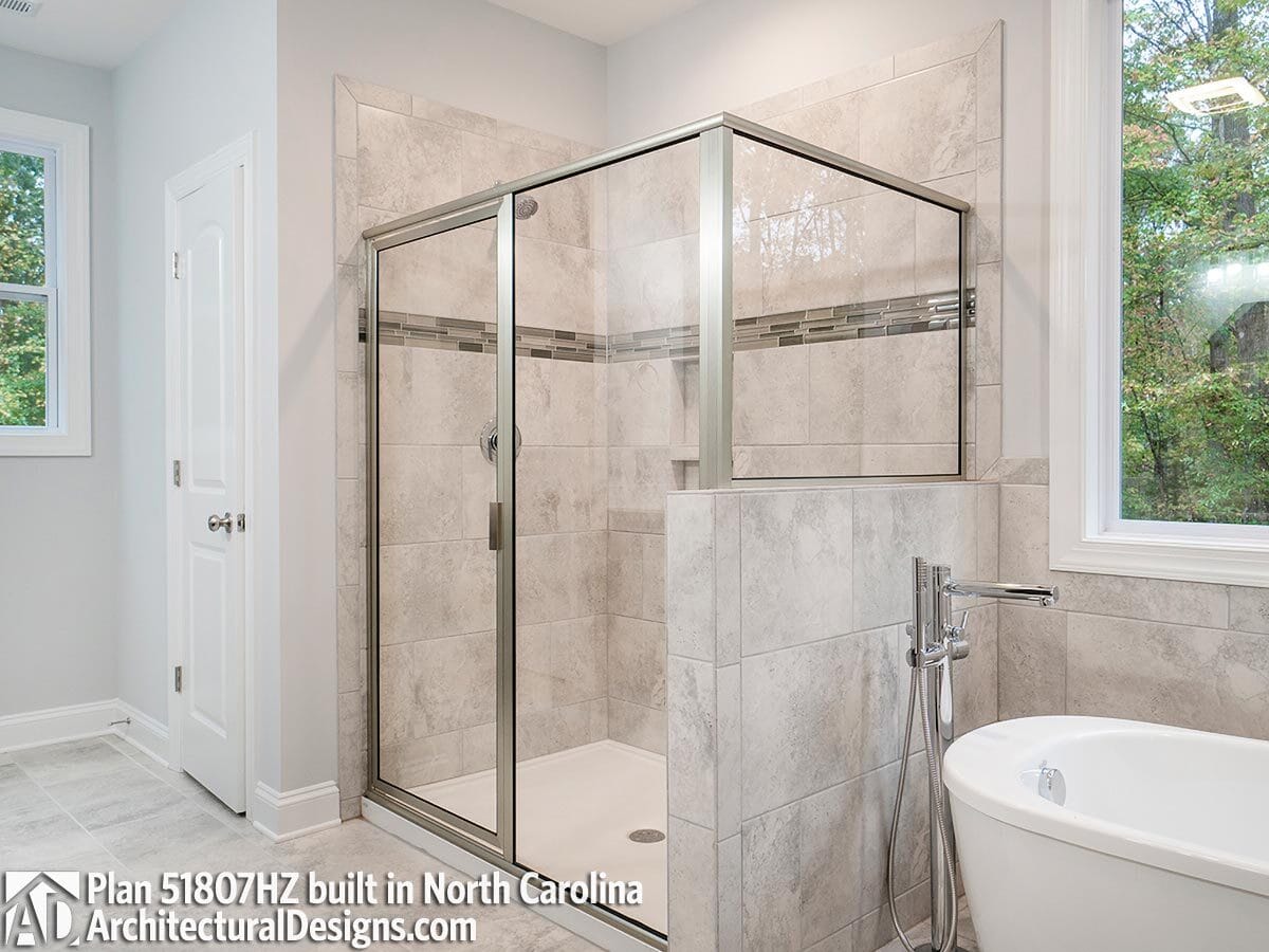 Primary bathroom with a walk-in shower and a soaking tub under the picture window.