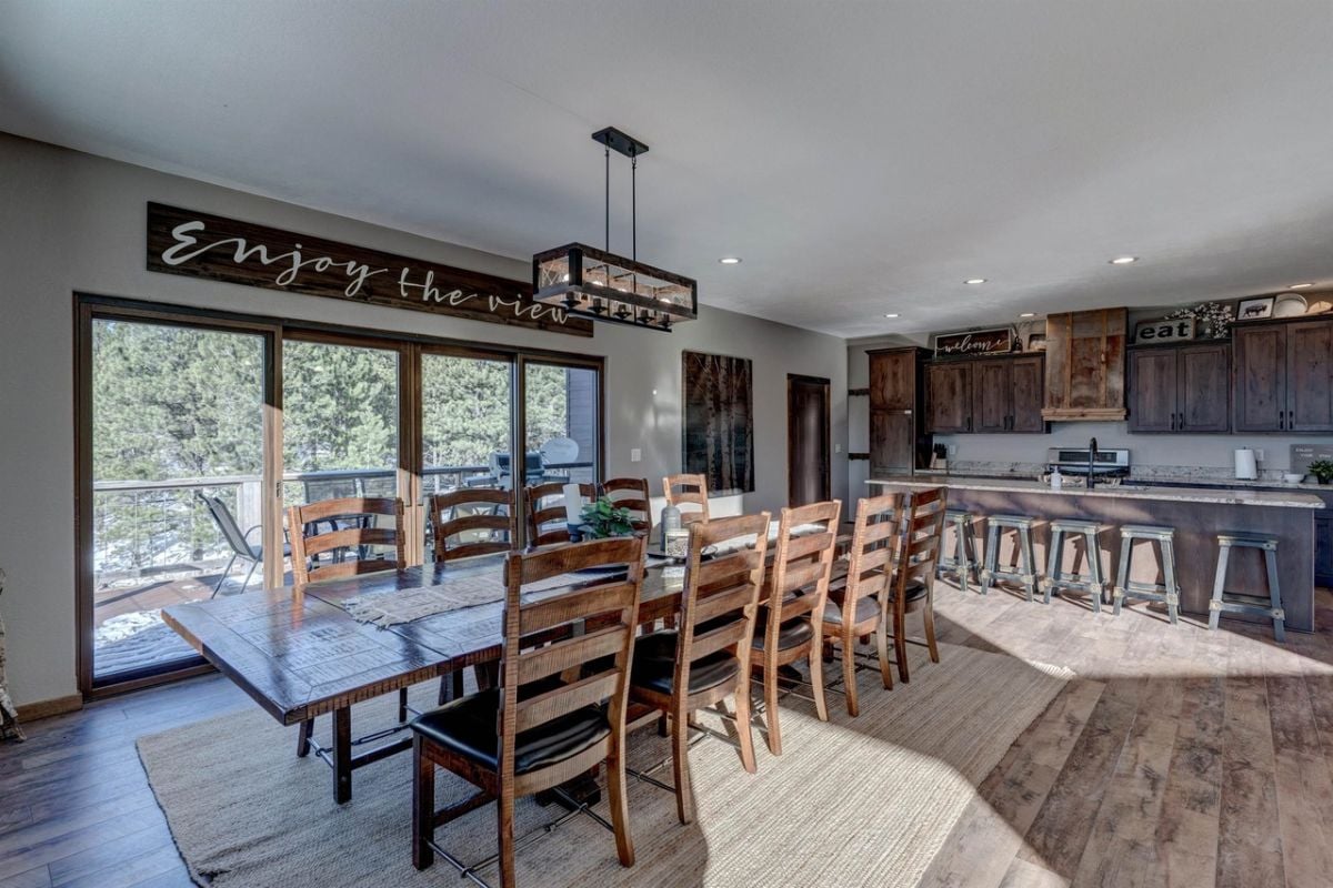 Dining room with a large wooden table, chairs and wooden floor.
