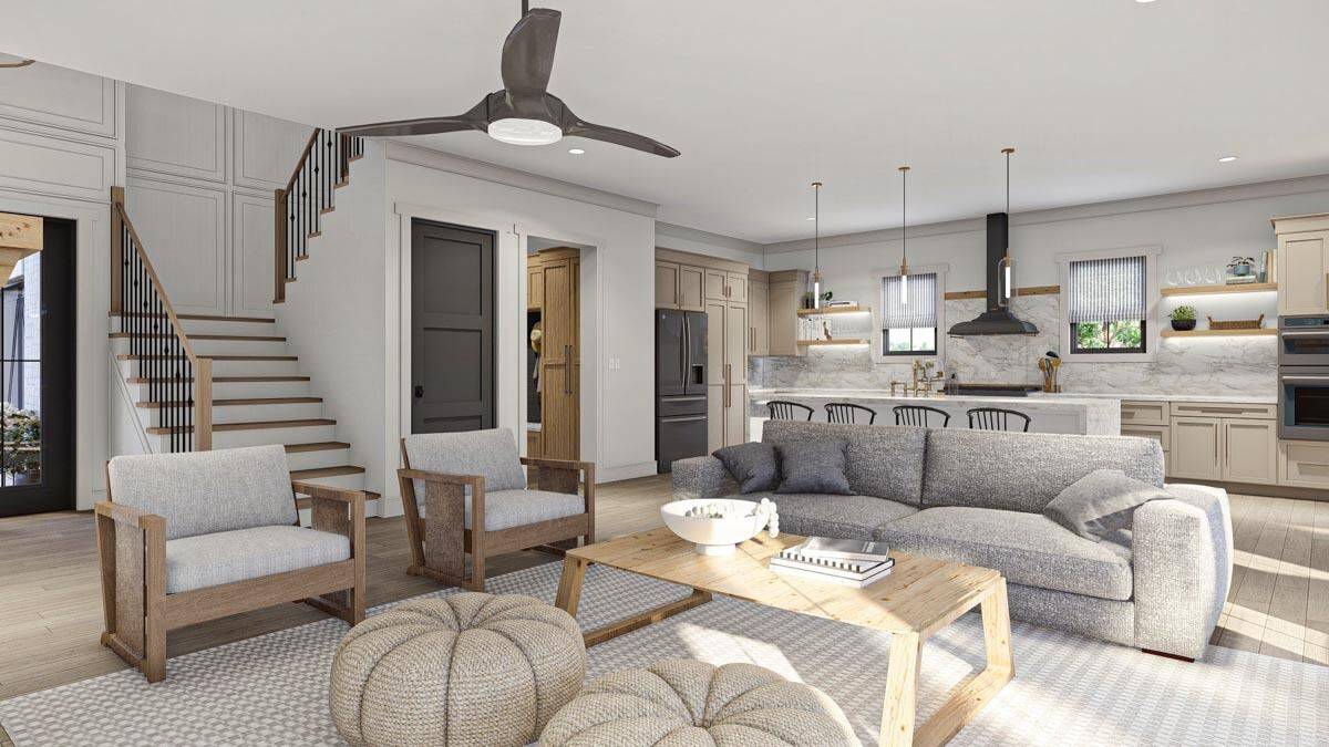 Great room with cushioned seats, a wooden coffee table, and a couple of poufs over the patterned area rug.