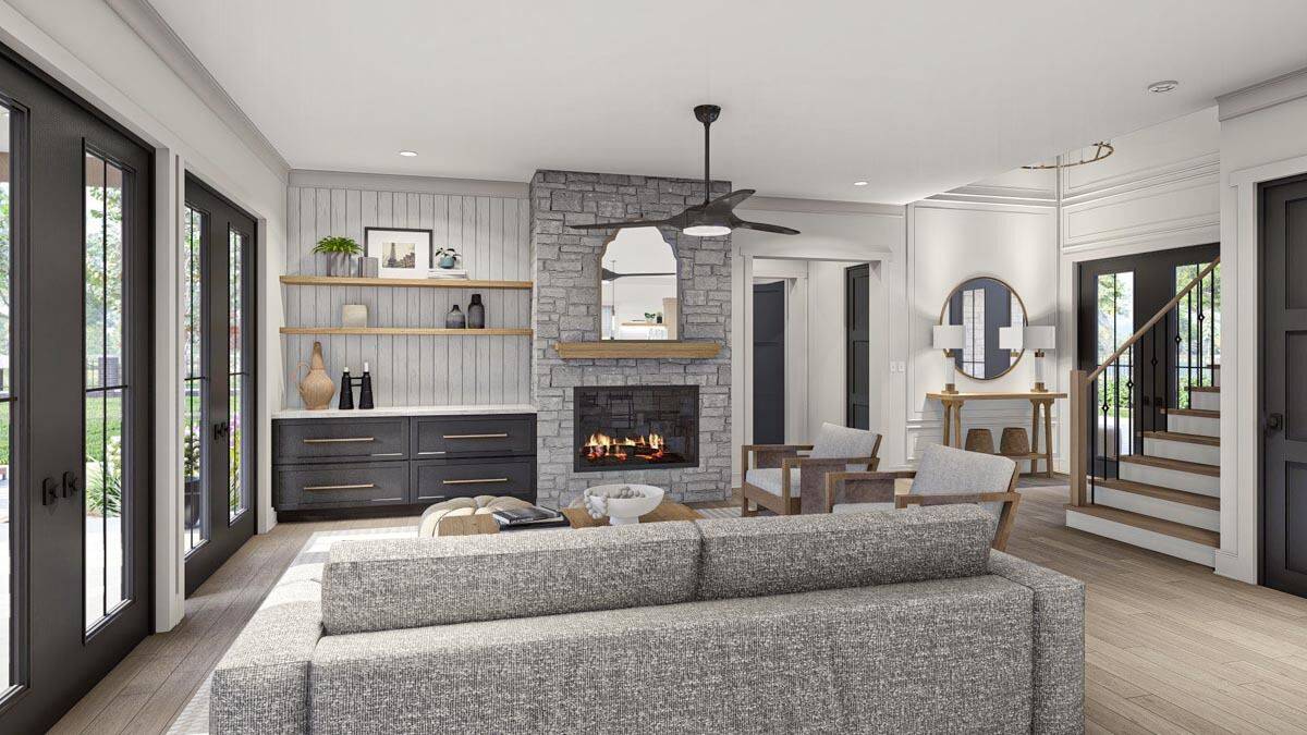 The great room includes a stone fireplace, a base cabinet, and floating shelves against the beadboard wall.
