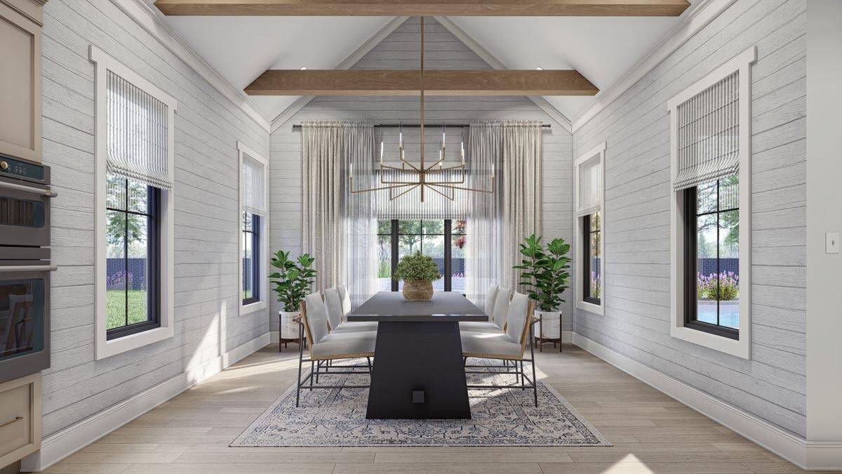 A cathedral ceiling accentuated with exposed wood beams crowns the dining room.