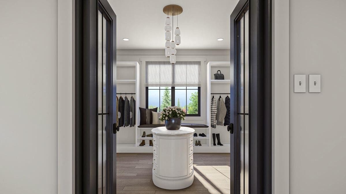 Primary walk-in closet with a French door, a round center table, and a window seat.