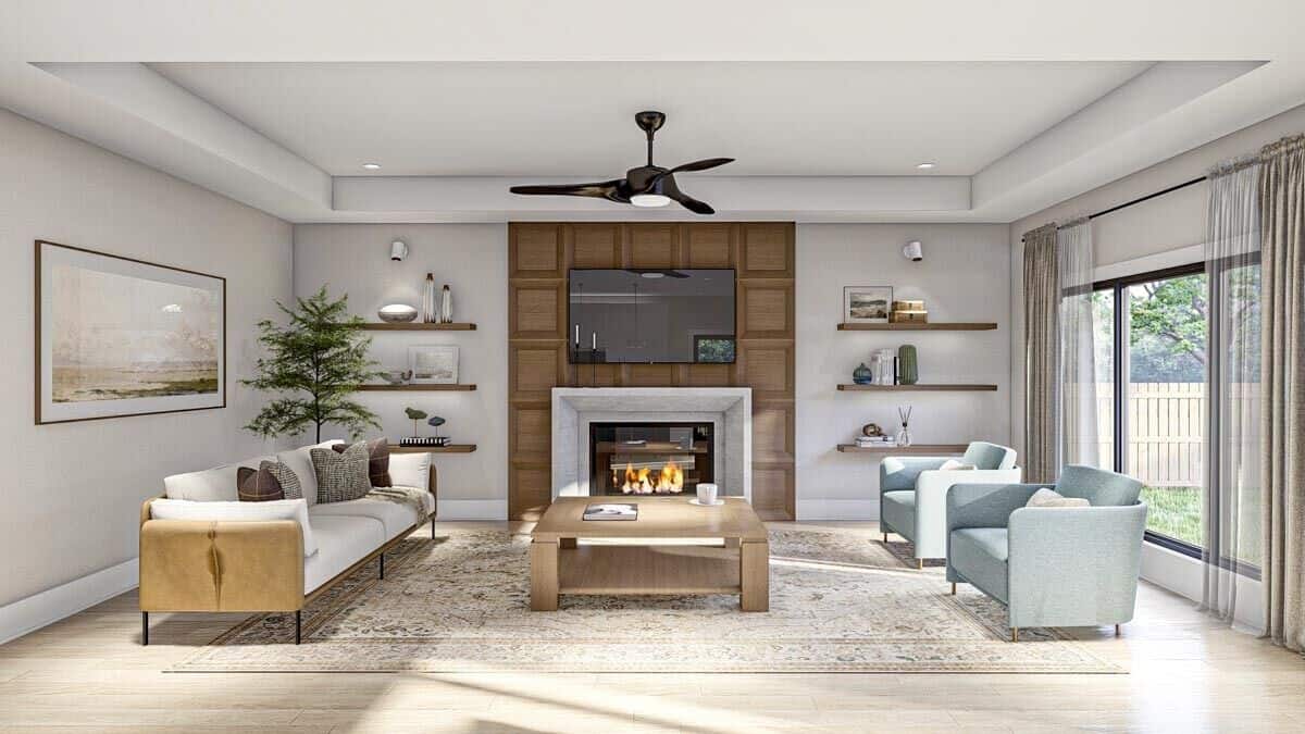Great room with modern seats, a fireplace with a TV on top, and a wooden coffee table under a tray ceiling.