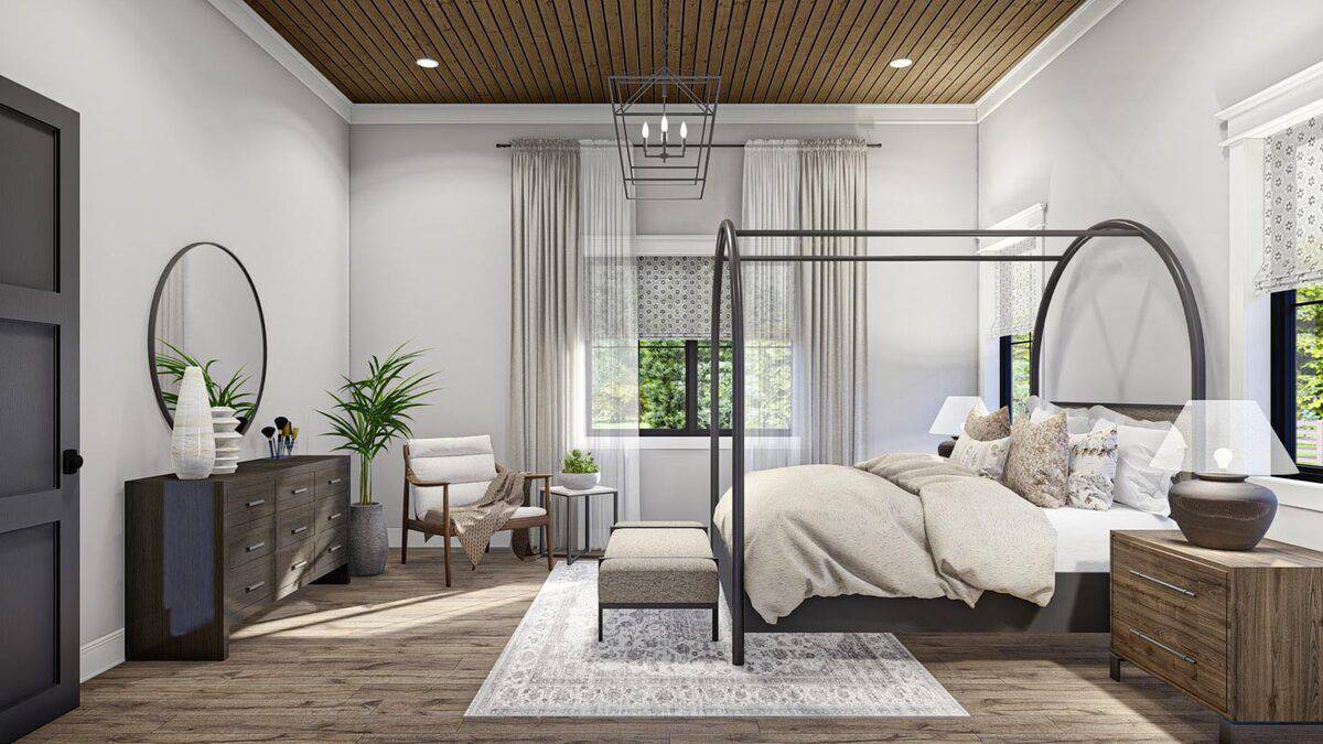 Primary bedroom with a a custom canopy bed, a cushioned bench, and a wooden dresser adorned with a round mirror.