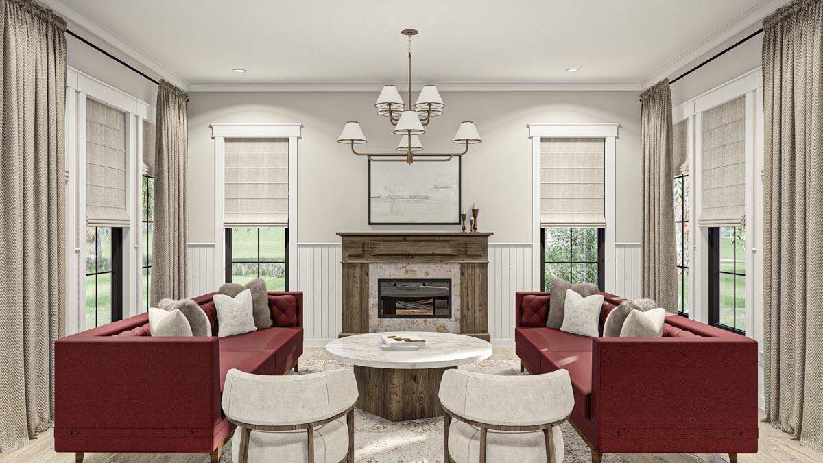 Great room with red sofas, a round coffee table, and a fireplace.
