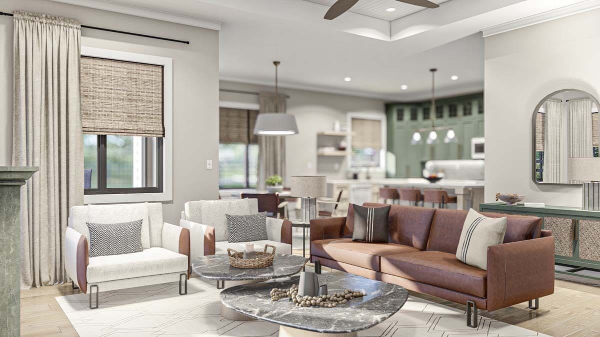 Great room with a leather sofa, white armchairs, and nesting coffee tables over a patterned area rug.