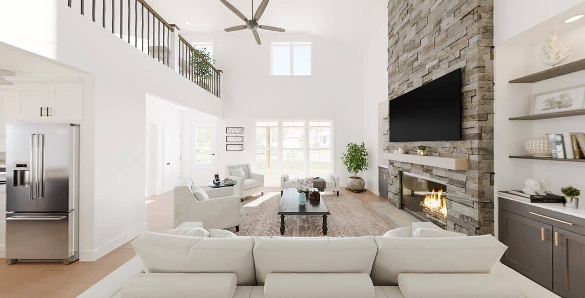 Great room with modern sofas, built-in cabinets, and a stone fireplace topped with a TV.