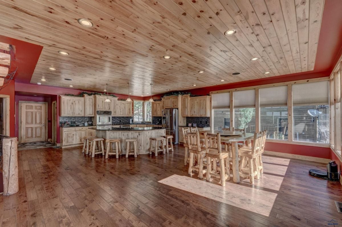 Kitchen with a large center island, wood flooring, and custom lights.