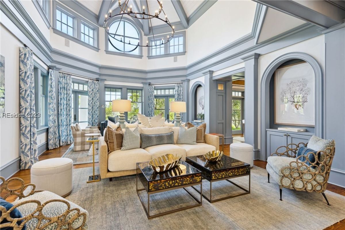 Living room with couches, chandelier and large rugs.