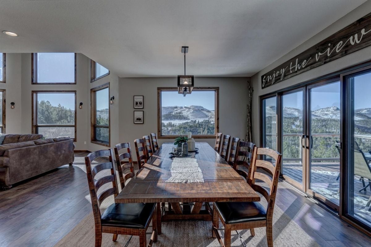 Dining room with a large wooden table, chairs and wooden floor.