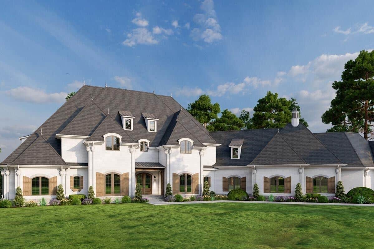 Front view of the house with hipped rooflines, shed dormers, shuttered windows, a covered entry, and an angled garage.