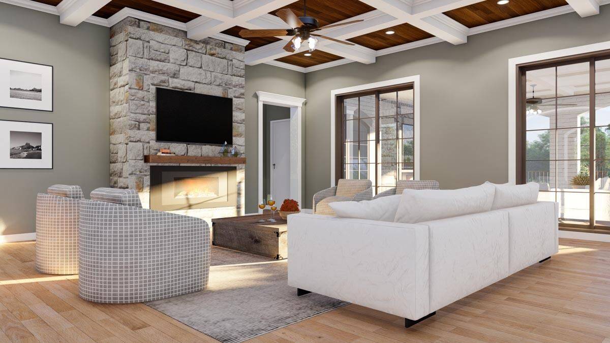 Great room with a coffered ceiling, a sectional sofa, checkered armchairs, and a stone fireplace with a TV on top.
