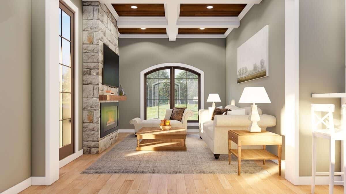 Hearth room with a stone fireplace, a wood-paneled ceiling, contemporary seats, and wooden tables over a distressed area rug.