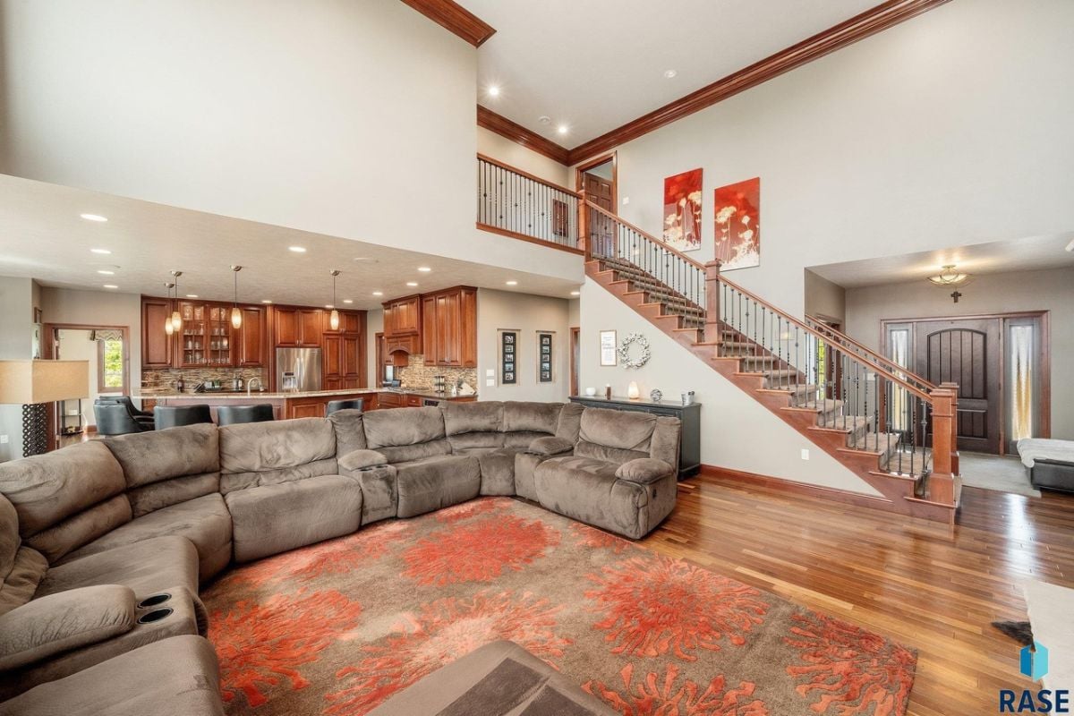Living room with couches, wood flooring and a large rug.