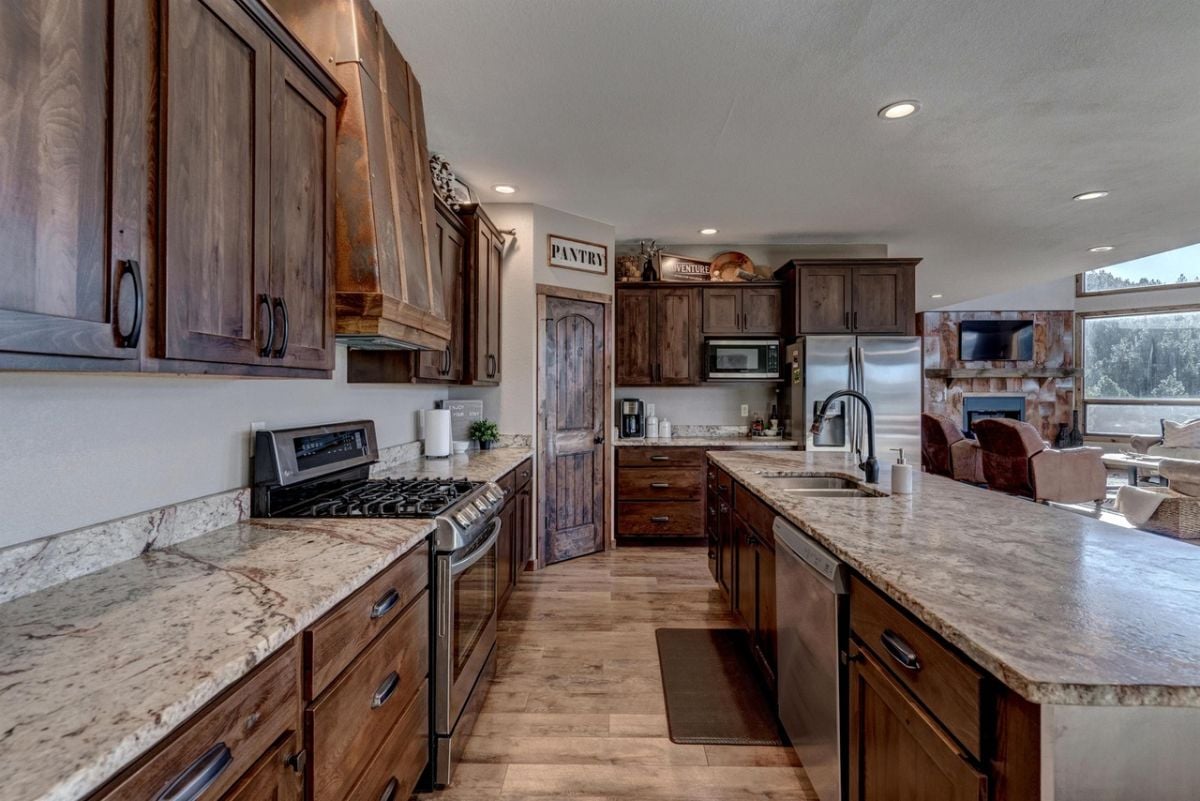 Kitchen with granite countertops, a large center island, and wooden cabinets.