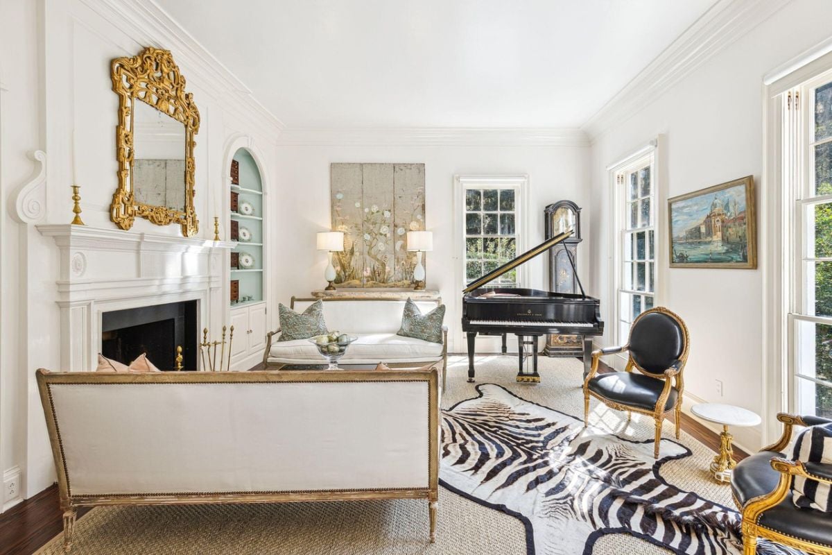 Living room with couches, piano and a fireplace.