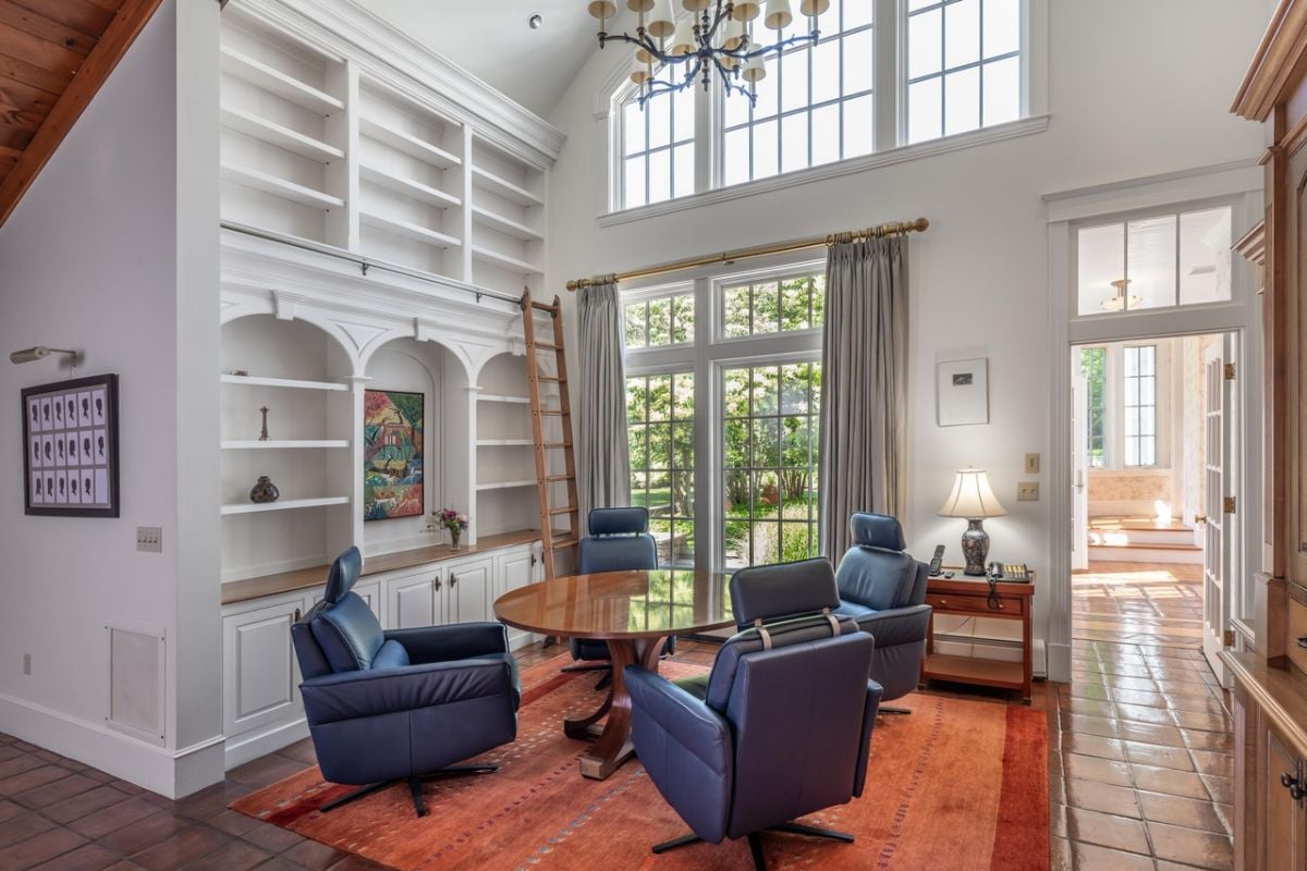 Breakfast nook with around table, chairs, chandelier and a large rug,