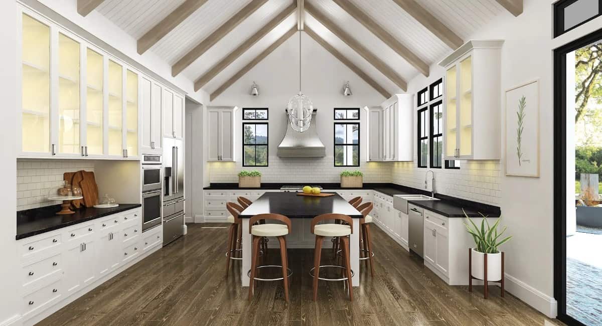 Kitchen with white cabinetry, contrasting countertops, modern appliances, and a center island surrounded by round bar stools.