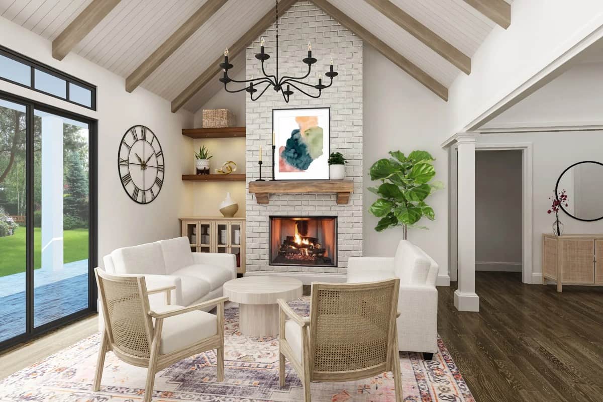 Great room with cushioned seats, a round coffee table, a brick fireplace, and a cathedral ceiling accentuated with exposed wood beams.