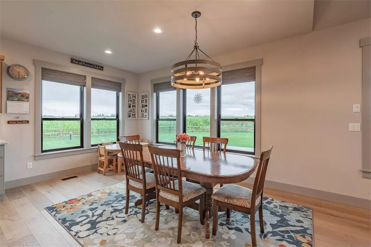 Dining room with a drum chandelier and an oval dining set that sits on a floral area rug.