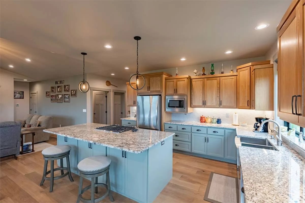 The kitchen includes double sinks under the framed windows.