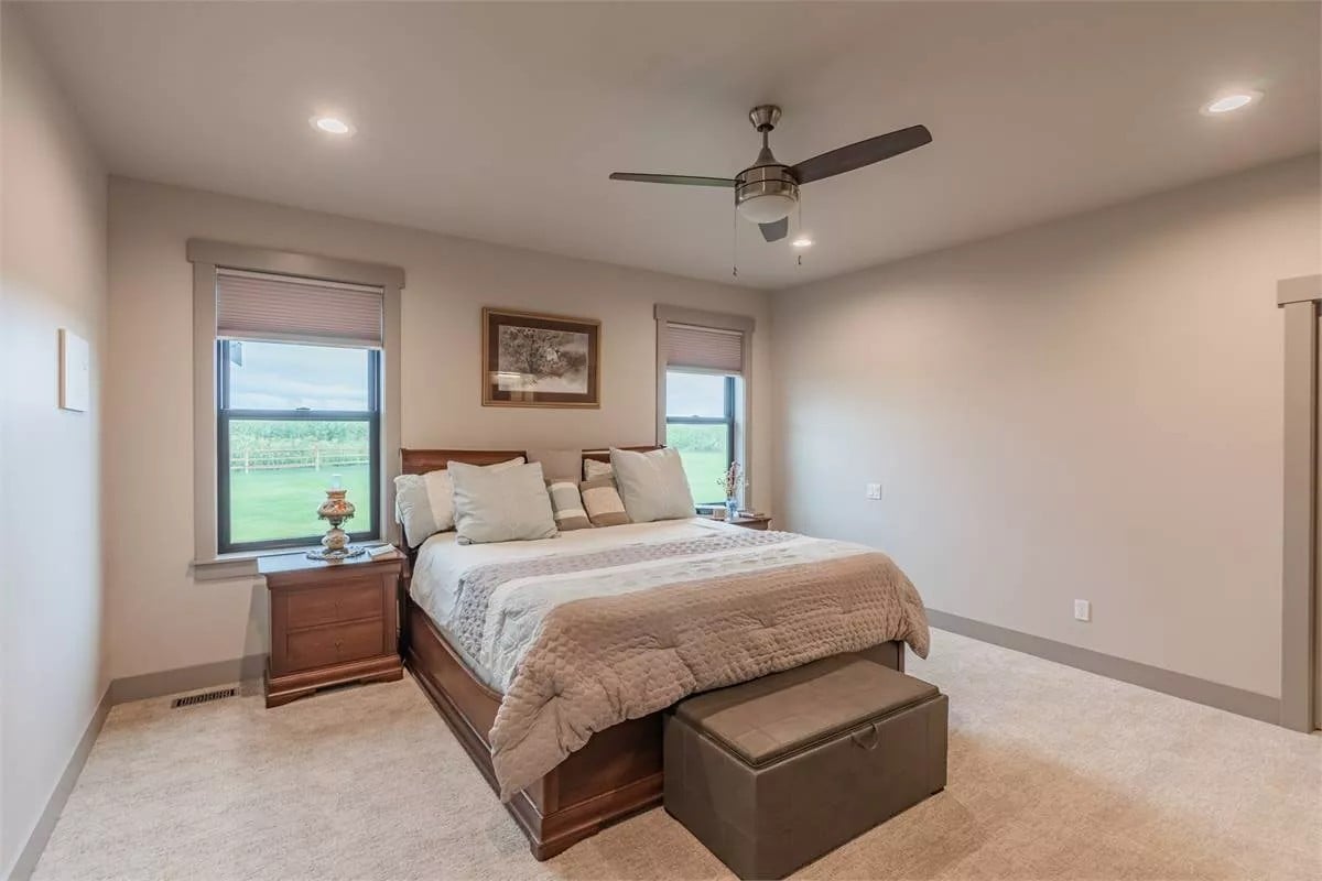 Primary bedroom with wooden nightstands and a matching bed complemented with a storage bench.