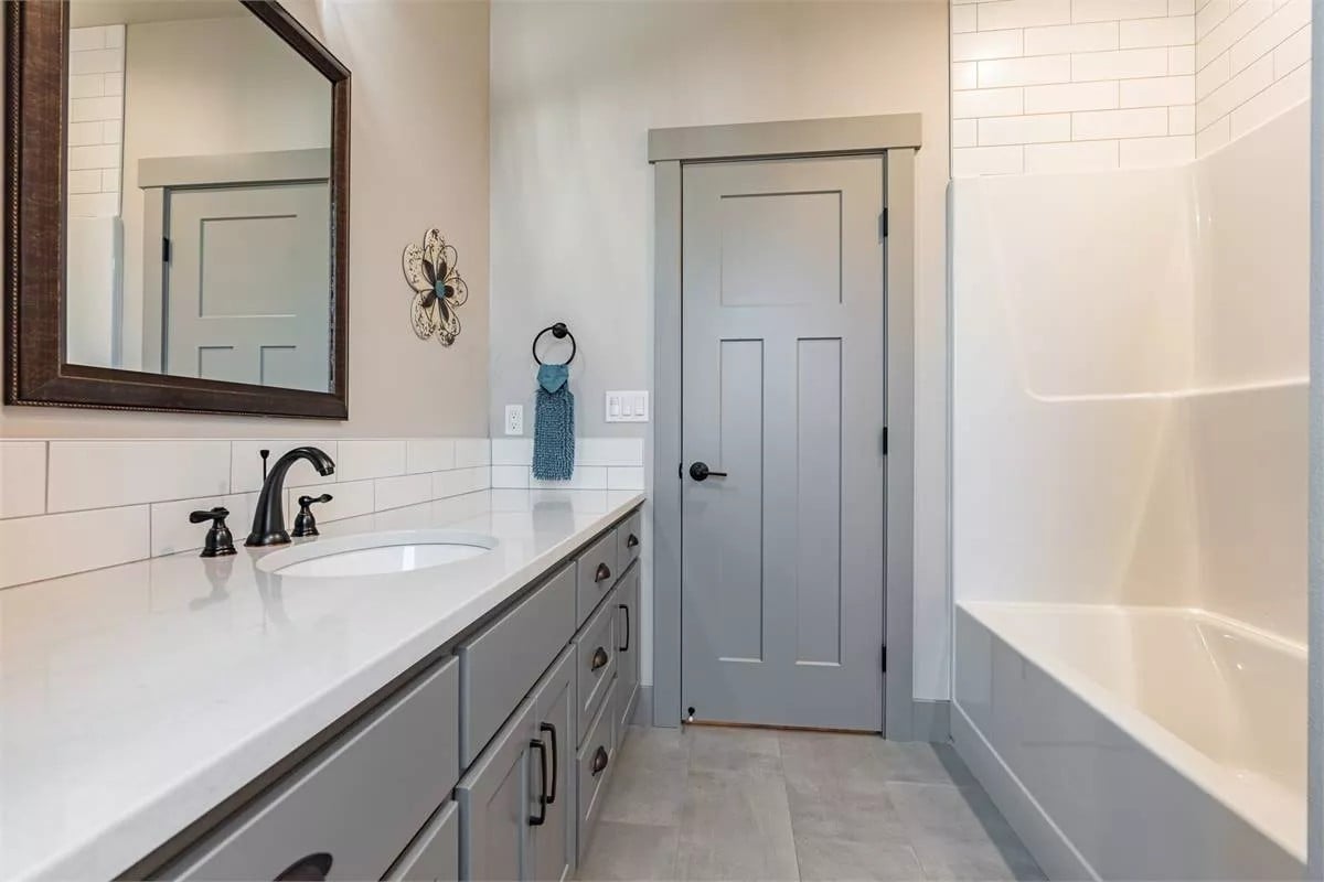 Bathroom with a large vanity and a drop-in bathtub.