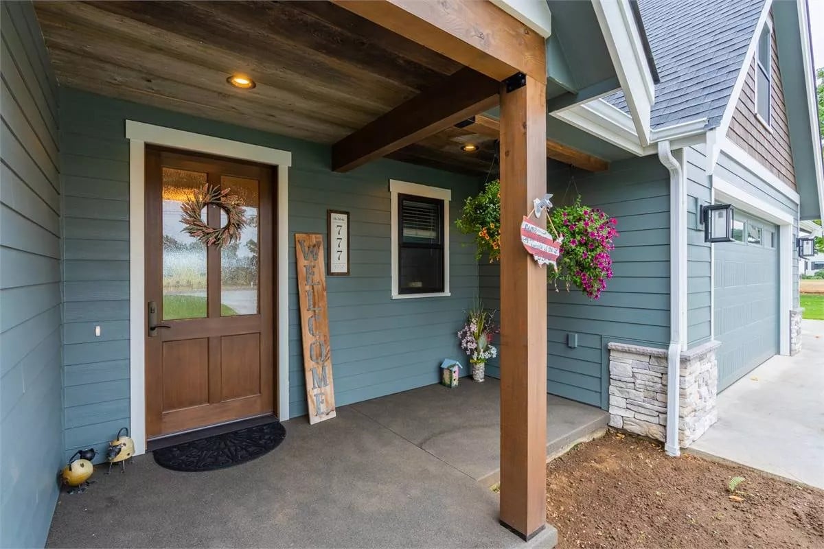 Covered entry with a glazed front door and concrete flooring.