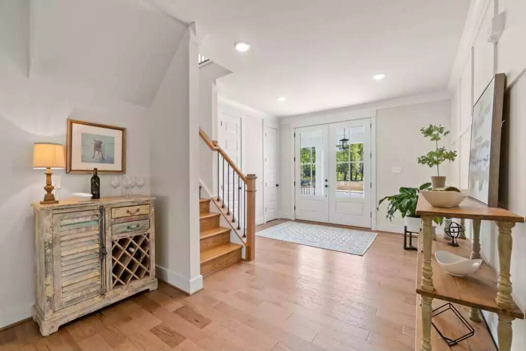 Foyer with a French entry door, a storage closet, a staircase, and a rustic cabinet with built-in wine rack.