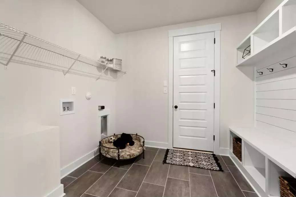 Mudroom with built-in cubbies, a built-in bench, coat hooks, and a pet bed.