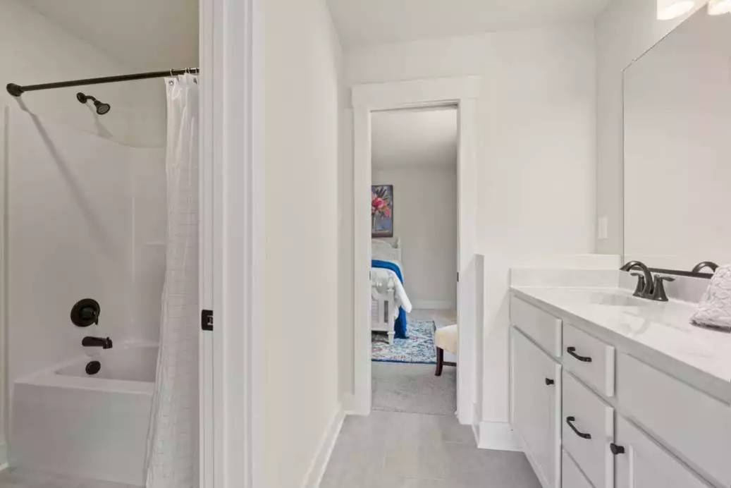 Jack and Jill bathroom with dual sink vanity and a tub and shower combo.