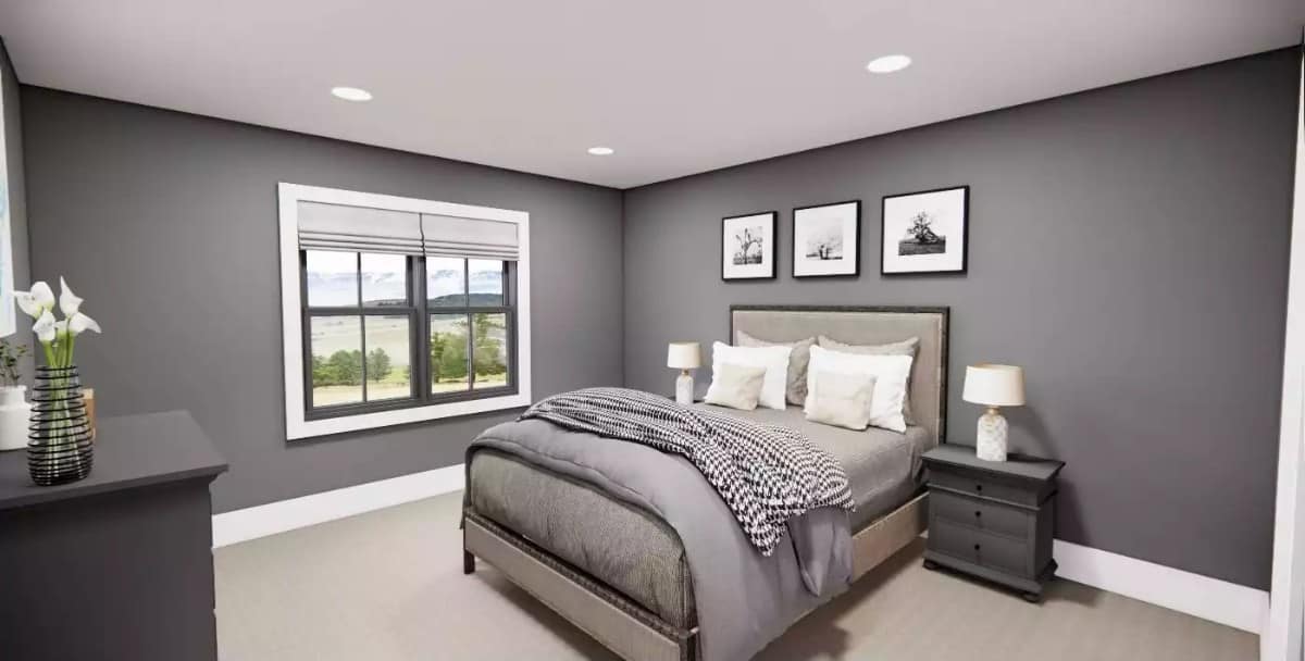 Lower level bedroom with gray walls and a wooden bed over the carpeted floor.