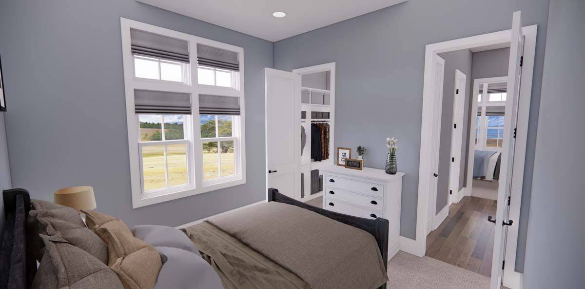 Bedroom with a dark wood bed, a white dresser, and a walk-in closet.