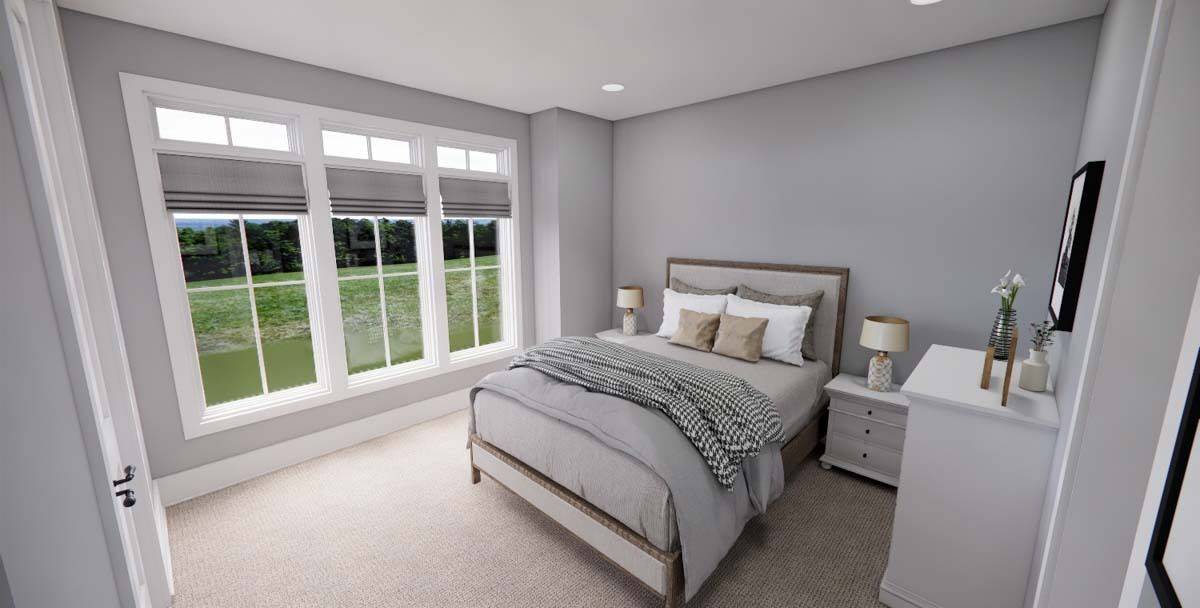 Bedroom with a wooden bed, white cabinets, and expansive yard views.