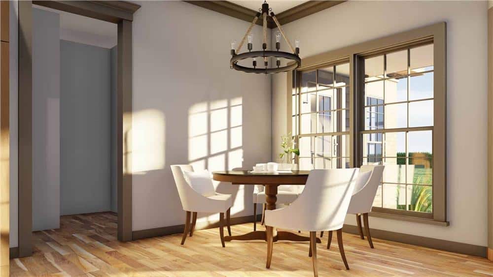 Breakfast nook with a round dining set and wooden framed windows overlooking the backyard.
