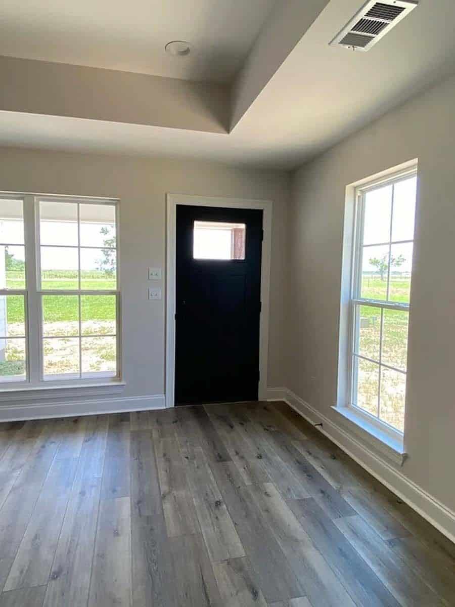 Living room with a glazed door, a tray ceiling, and huge framed windows.