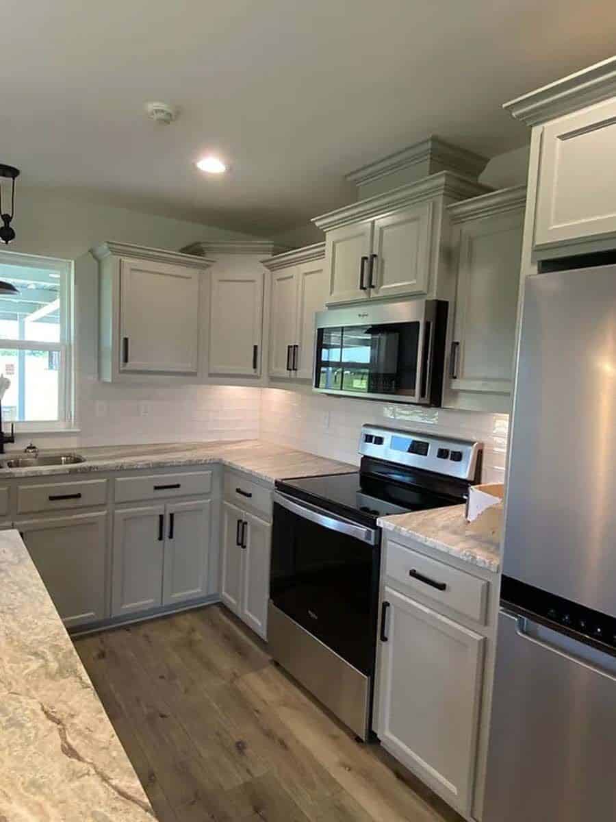 Kitchen with custom cabinetry, granite countertops, and modern appliances.