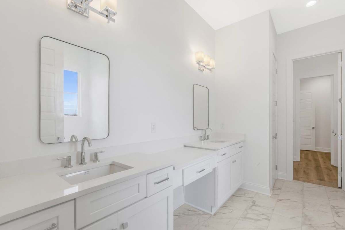 Primary vanity with two sinks and a makeup counter in the middle.