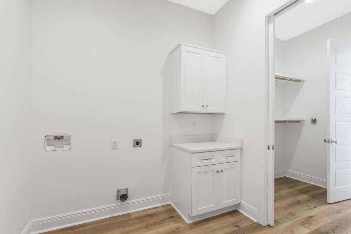Utility room with white cabinets and a small counter.