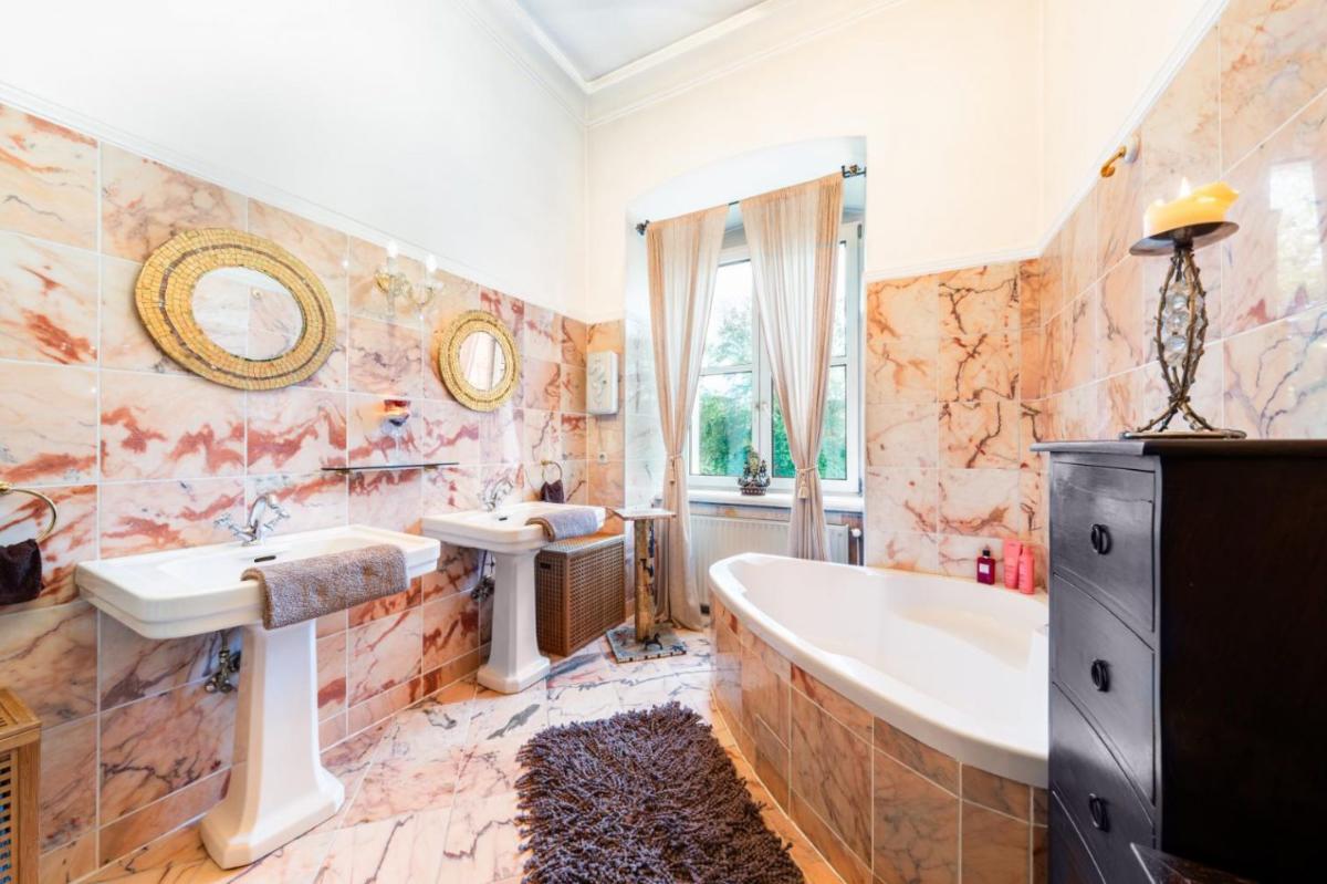Bathroom with dial sinks, a soaking tub and tile flooring.