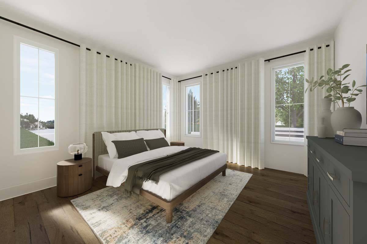 Primary bedroom with a wooden bed, a gray dresser, and plenty of windows flooding the room with natural light.