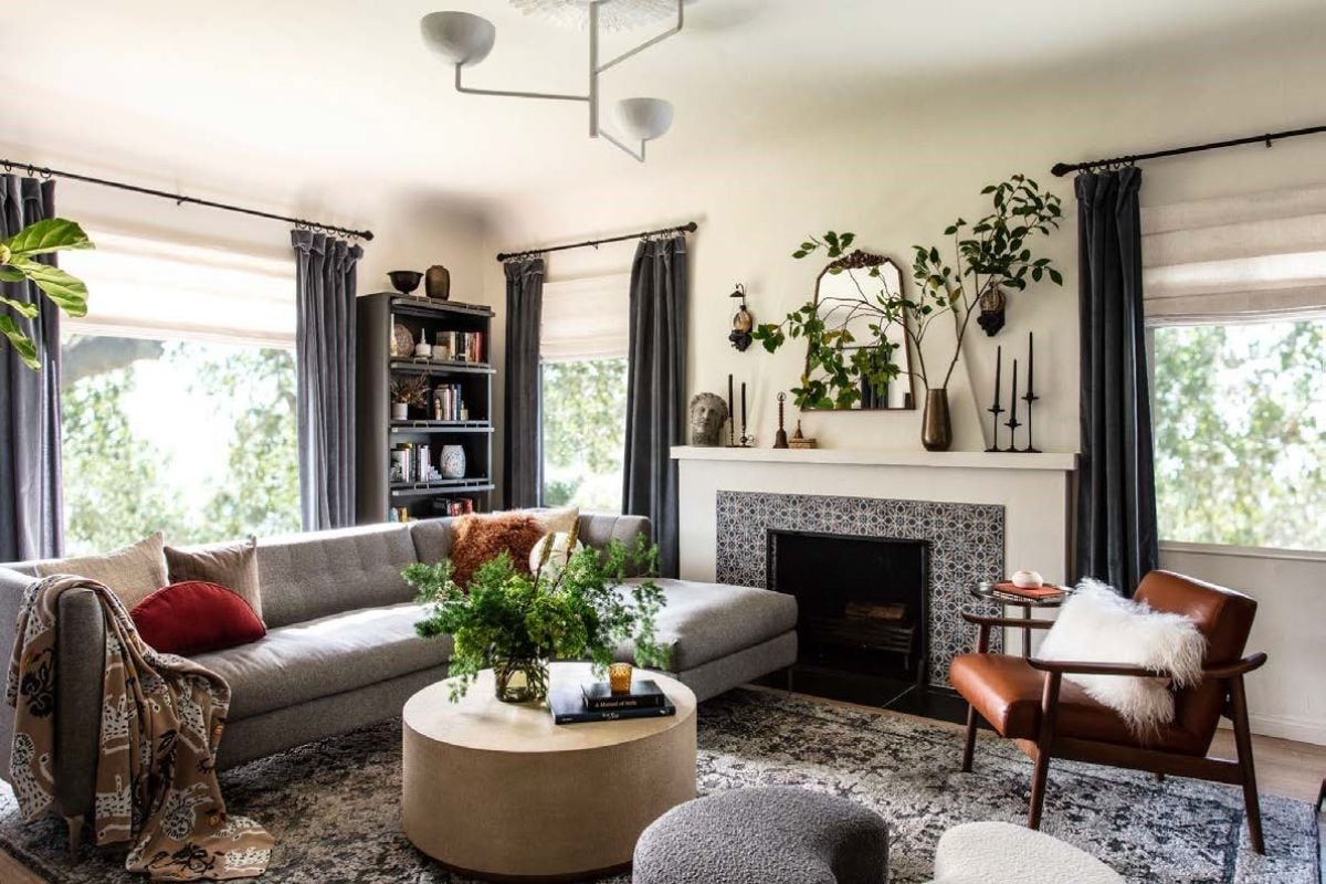 Living room with couches, fireplace, chandelier and a large rug.